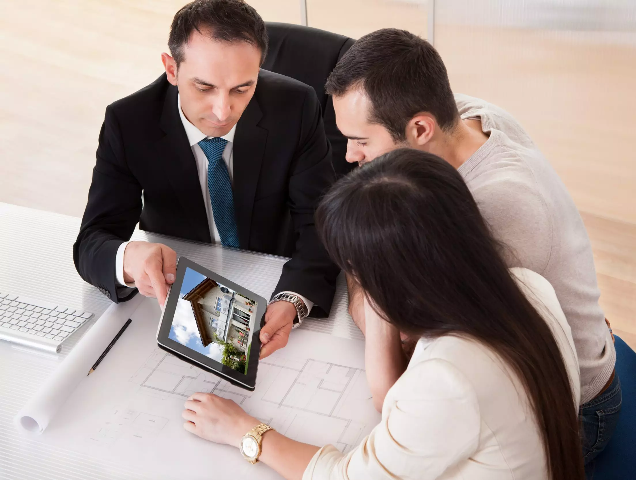 A realtor showing a home to homebuyers on a tablet